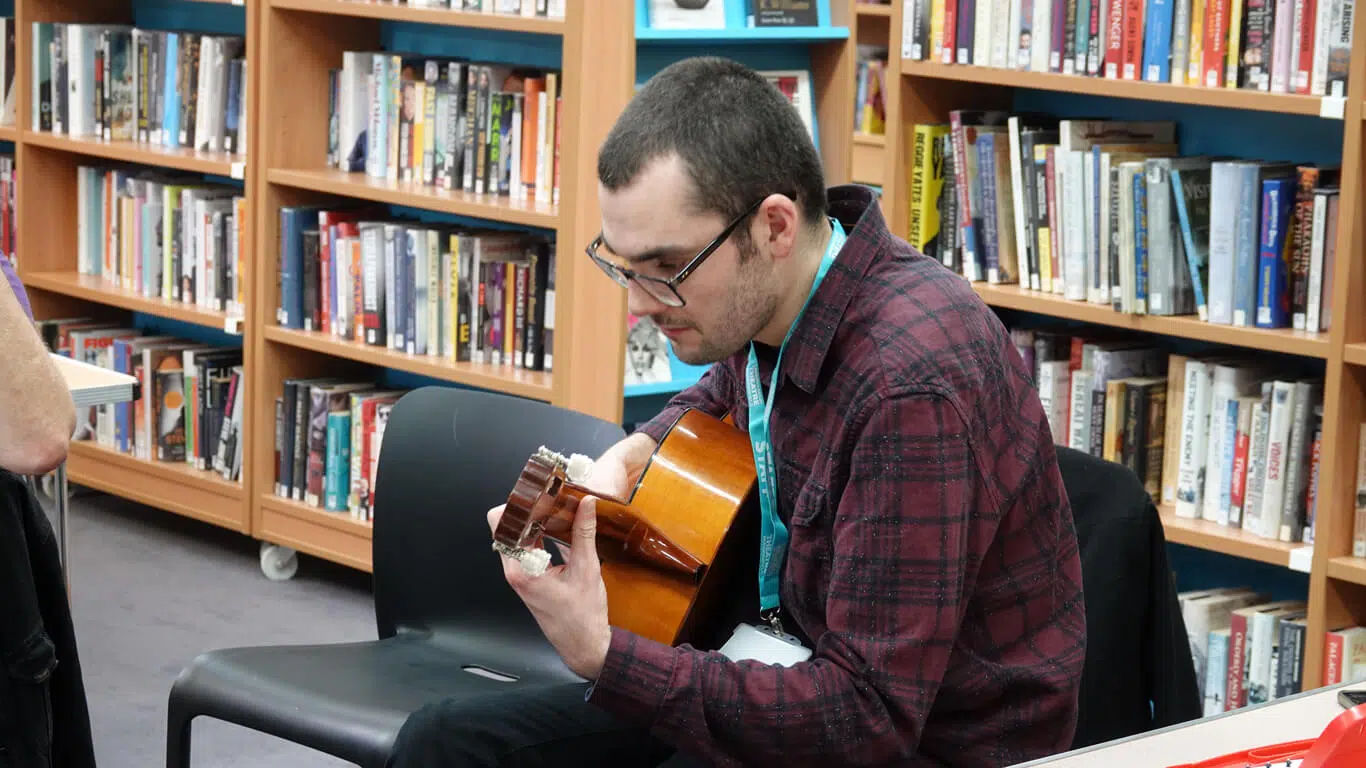 Henry at school workshop playing guitar